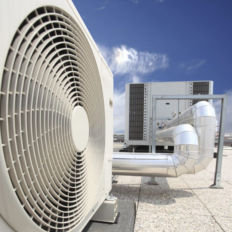 Système de climatisation sur un toit, avec ventilateur et tuyaux en métal.